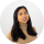 A woman with long dark hair smiling at the camera against a plain light background.