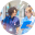 Two healthcare professionals in blue medical scrubs standing together, likely doctors or nurses in a clinical setting.