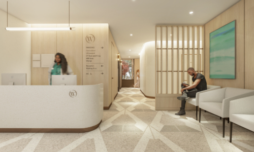 A modern medical office reception area featuring a curved white reception desk with directional signage, geometric marble flooring, light wood paneling, and a waiting area with white seating where a man sits while a receptionist works at the desk.